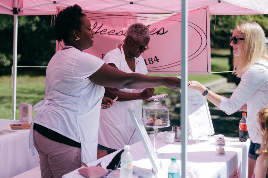 two women in white shirts beside stall